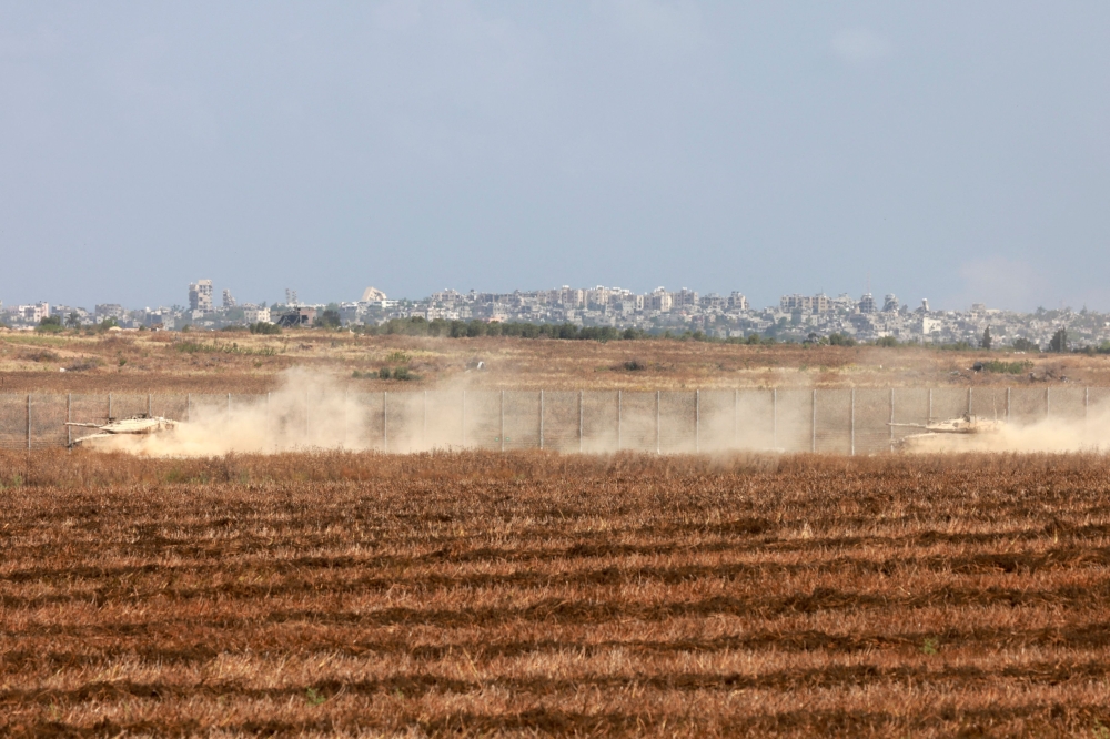 Israeli military vehicles roll near the border with the Gaza Strip on Sunday, amid the ongoing conflict. - AFP