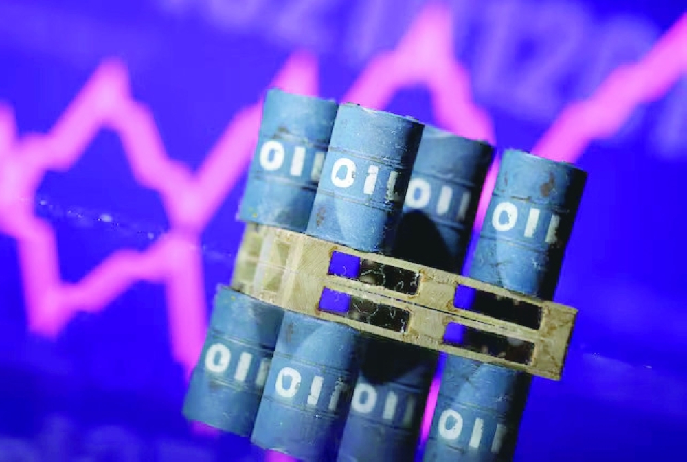 Miniatures of oil barrels and a rising stock graph are seen in this illustration. — Reuters