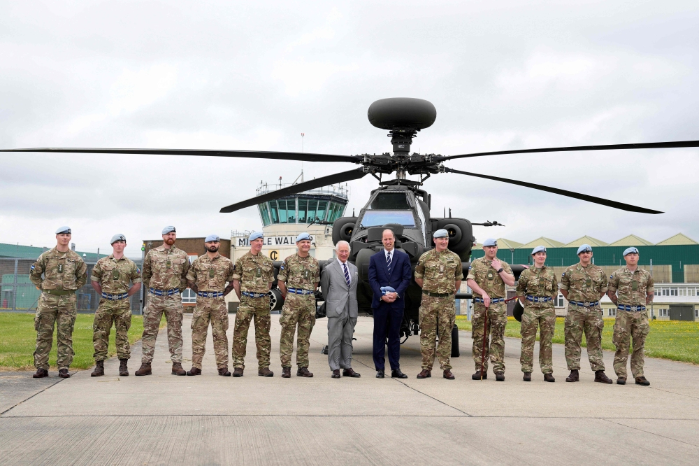 Britain's King Charles III (C-L) officially hands over the role of Colonel-in-Chief of the Army Air Corps to Britain's Prince William, Prince of Wales (C-R) in front of an Apache helicopter at the Army Aviation Centre in Middle Wallop, England. — AFP 