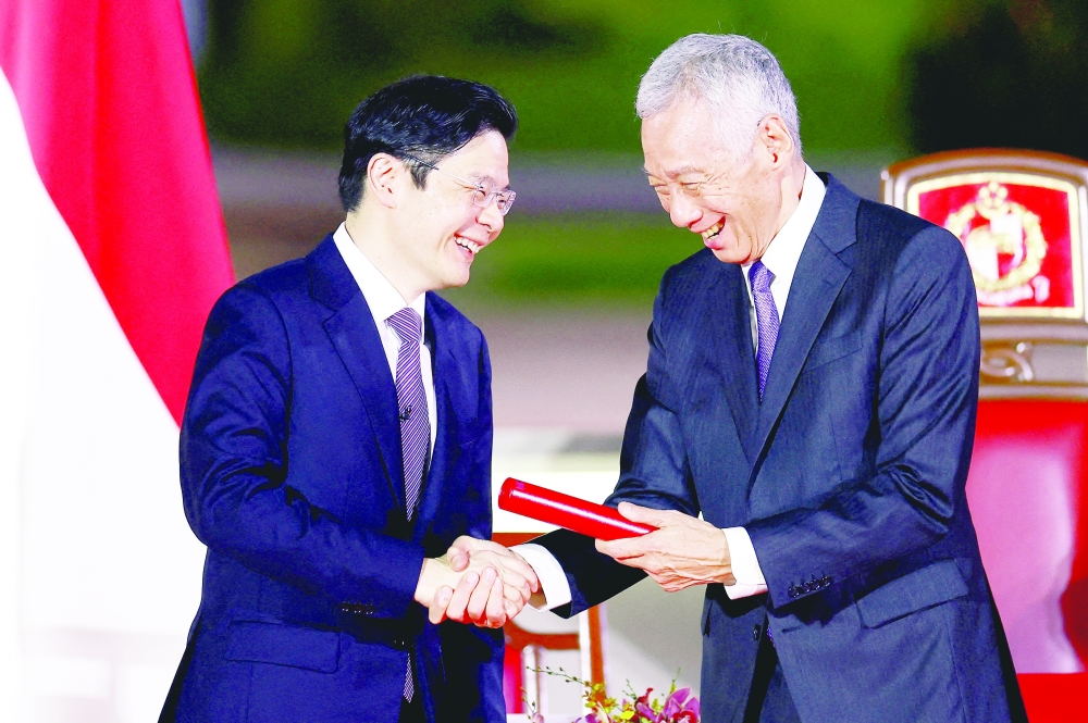 Singapore's new Prime Minister Lawrence Wong shakes hands with Senior Minister Lee Hsien Loong as he is sworn in as Singapore's fourth Prime Minister at the Istana, in Singapore, on Wednesday. — Reuters