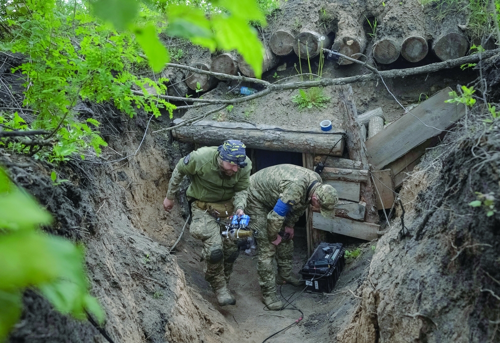 A Ukrainian serviceman of the attack drones battalion of the Achilles, 92nd brigade carries a first-person view (FPV) drone before it flies, in a Kharkiv region. 