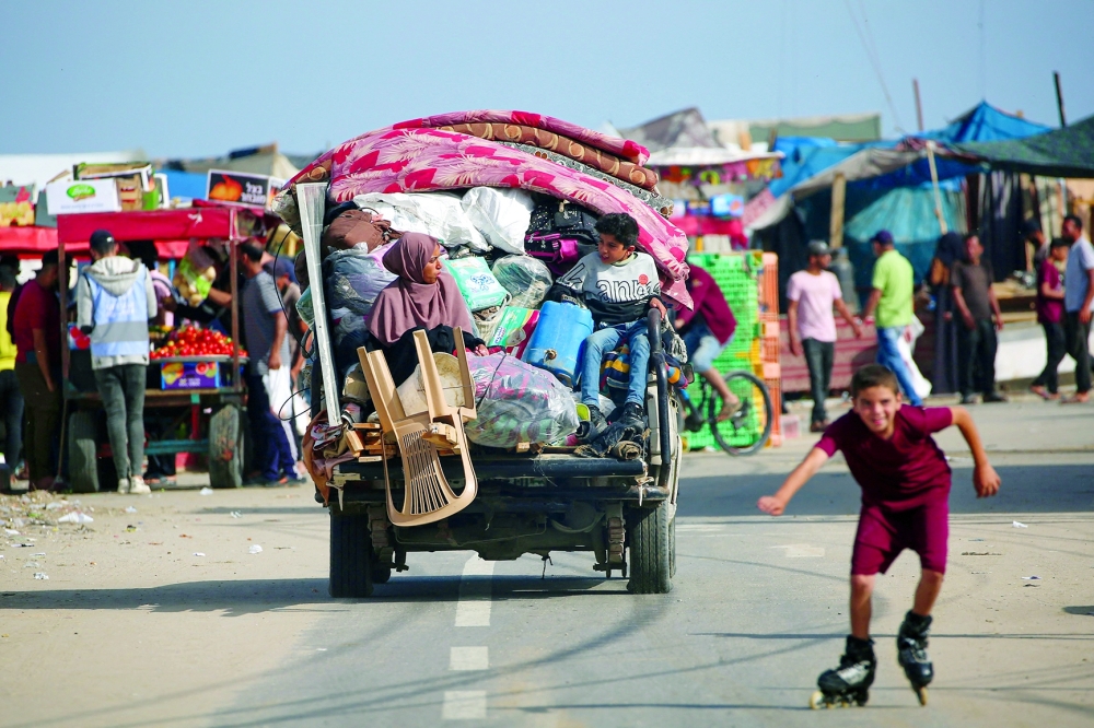A displaced Palestinian family arrives at a temporary camp in Rafah