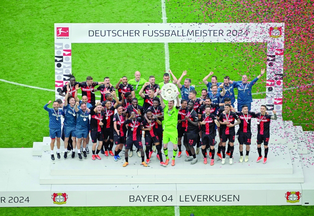 Bayer Leverkusen's team poses with the trophy.— AFP