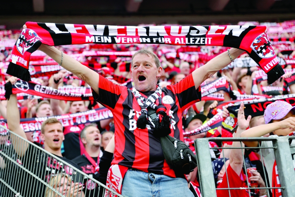 Leverkusen fans hold their scarves aloft.— REUTERS