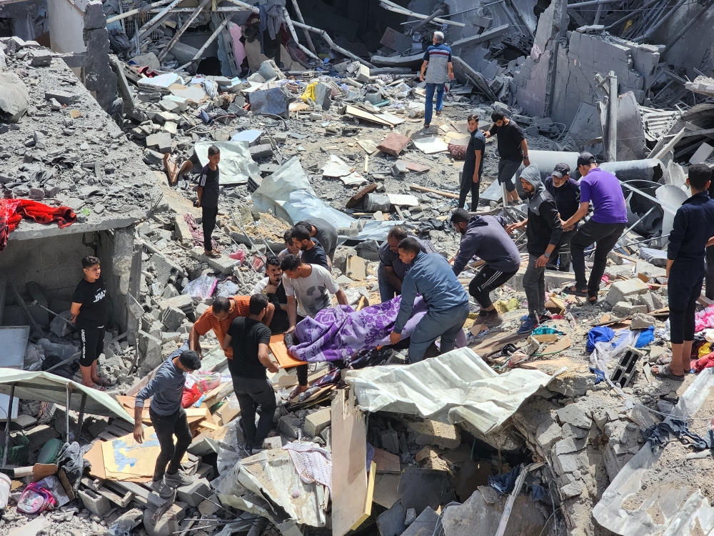 Palestinians carry the body of a person killed in an Israeli strike on a house in Jabalia refugee camp in the northern Gaza Strip on Saturday. — Reuters