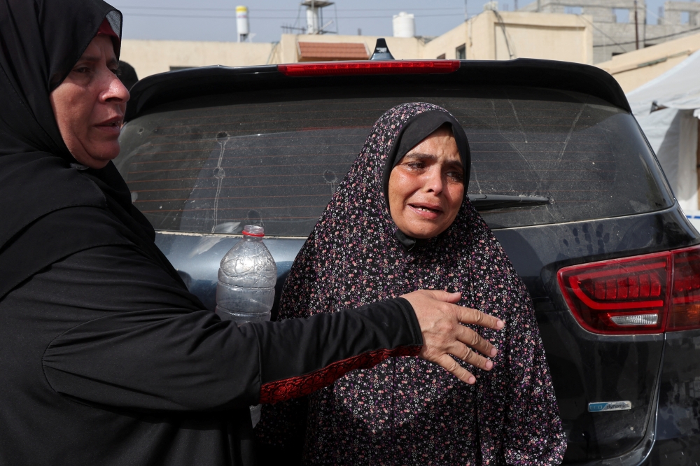 A mourner is comforted as she grieves during the funeral of Palestinians killed in an Israeli strike at Al Aqsa hospital in Deir Al Balah in the central Gaza Strip on Sunday. - Reuters