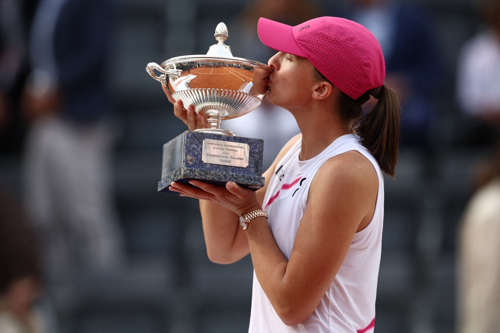 Iga Swiatek celebrates with the trophy.— REUTERS
