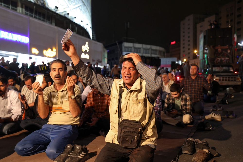 Iranians pray for President Ebrahim Raisi and Foreign Minister Hossein Amir-Abdollahian in Valiasr Square in central Tehran on May 19, 2024