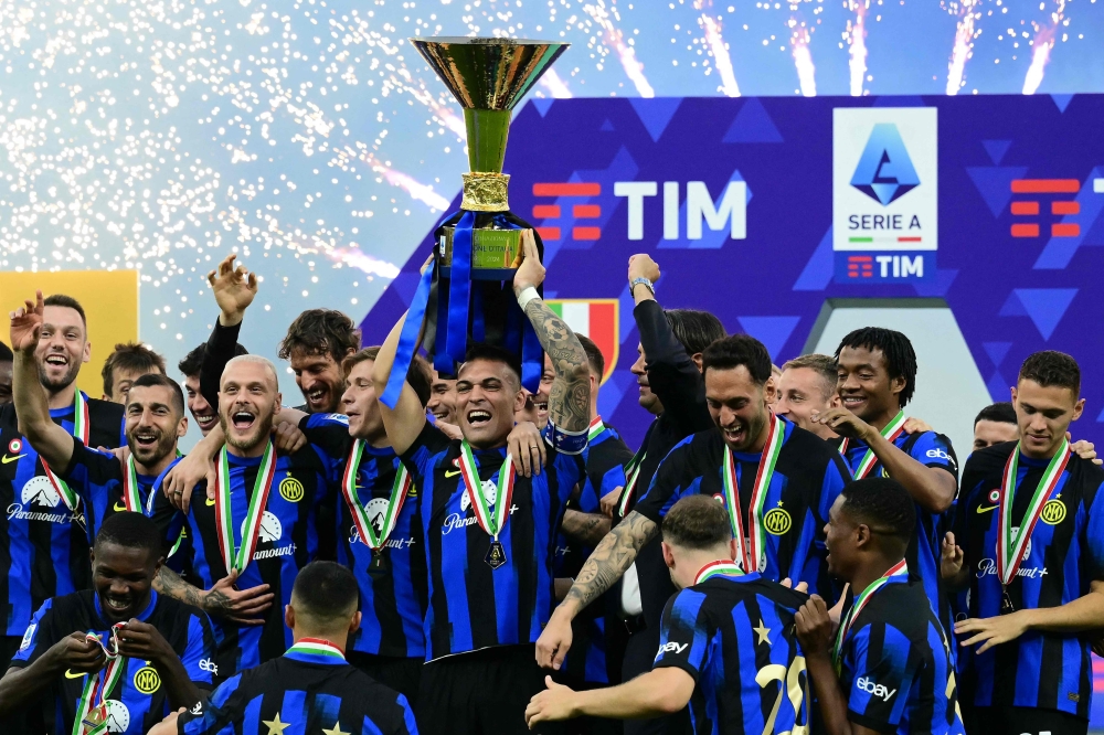 Inter Milan's Argentine forward #10 Lautaro Martinez lifts the trophy with teammates during a ceremony for the Italian Champions following the Italian Serie A football match between Inter Milan and Lazio in Milan, on May 19, 2024. Inter celebrates his 20th Scudetto. (Photo by Marco BERTORELLO / AFP)

