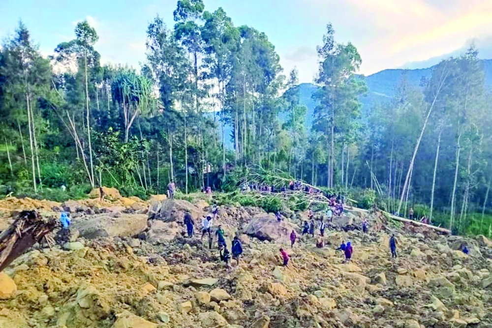 People gather at the site of a landslide in Maip Mulitaka in Papua New Guinea's Enga Province. 