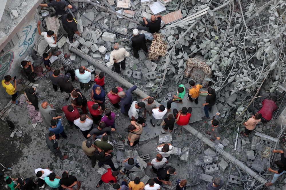 Palestinians search for survivors at the site of an Israeli strike on the Al-Daraj neighbourhood in Gaza. — AFP 