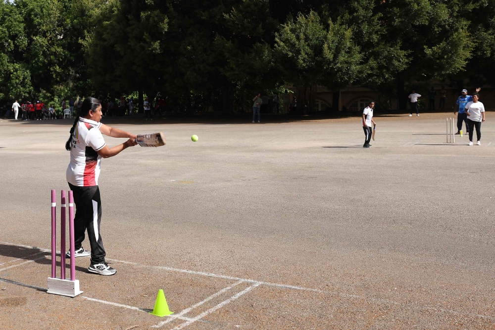 A migrant living in Lebanon plays a shot during a cricket match held at a parking lot in Beirut 