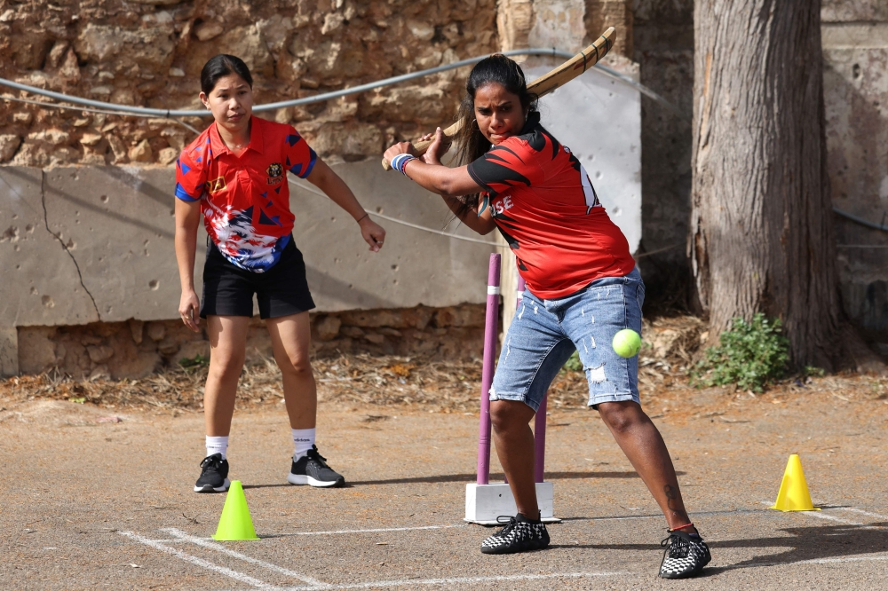 Migrants living in Lebanon compete in a cricket match held at a parking lot in Beirut