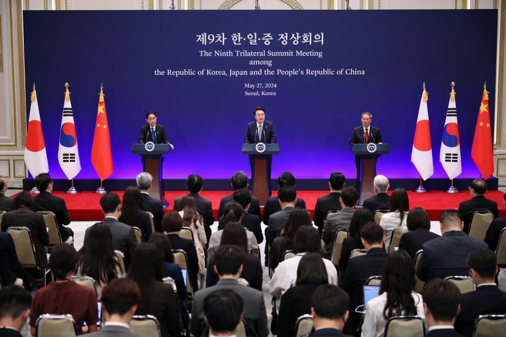 S Korean President Yoon Suk Yeol speaks as Japanese PM Fumio Kishida and Chinese Premier Li Qiang listen during a joint press conference in Seoul, — Reuters 