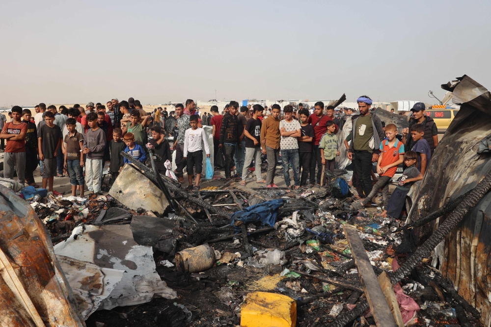 Palestinians gather at the site of an Israeli strike on a camp for internally displaced people in Rafah. — AFP 