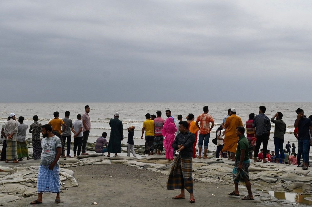 People gather at a sea beach after Cyclone remal's landfall in Kuakata 