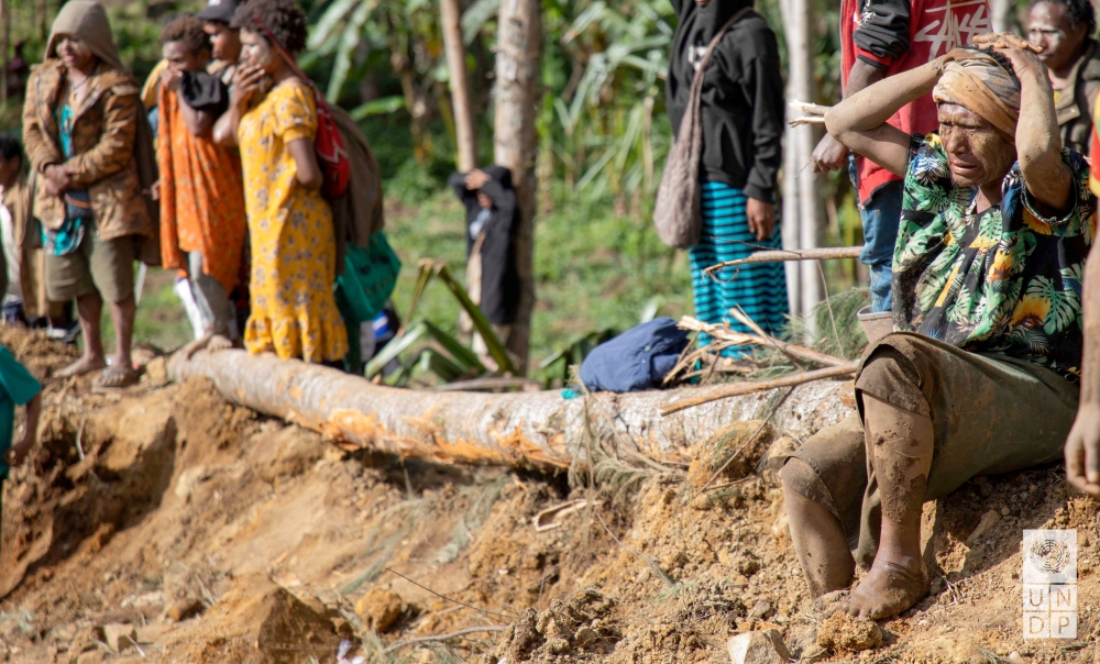 Onlookers react as people clear an area at the site of a landslide in Yambali village, Enga Province, Papua New Guinea. — Reuters 