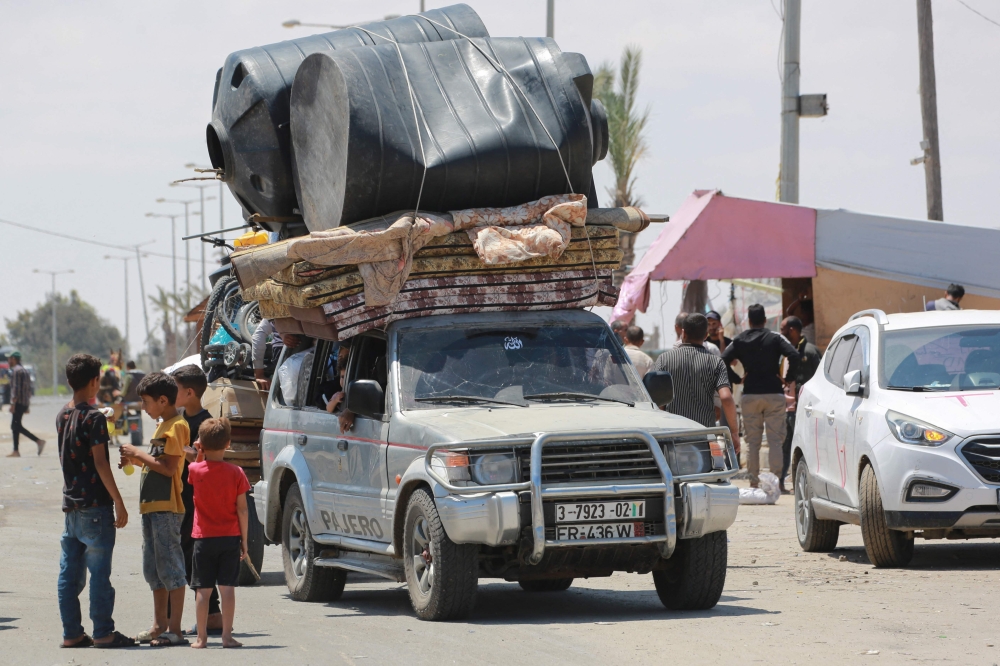 Palestinians fleeing with their belongings drive their vehicles in Rafah in the southern Gaza Strip on Wednesday. — AFP