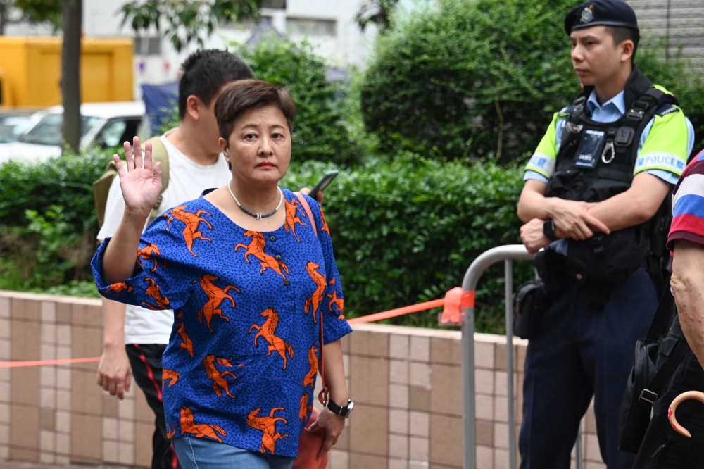 Hong Kong democrat Helena Wong (L) waves as she arrives at the West Kowloon Magistrates' Court in Hong Kong on Thursday. — AFP