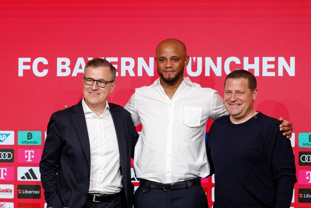 (L-R) Bayern Munich's CEO Jan-Christian Dreesen, the club's new head coach Vincent Kompany and the director of sport Max Eberl pose for a photo at the end of a press conference during Kompany's official presentation as new coach of German Bundesliga first division football team FC Bayern Munich on May 30, 2024 in Munich, southern Germany. Bayern Munich's long search to fill their vacant head coaching position is over with the German giants naming Vincent Kompany as manager in a shock move. The 38-year-old Belgian, a surprise choice with his Burnley side relegated from the Premier League this season, has penned a three-year deal with the German record club. (Photo by Michaela STACHE / AFP)

