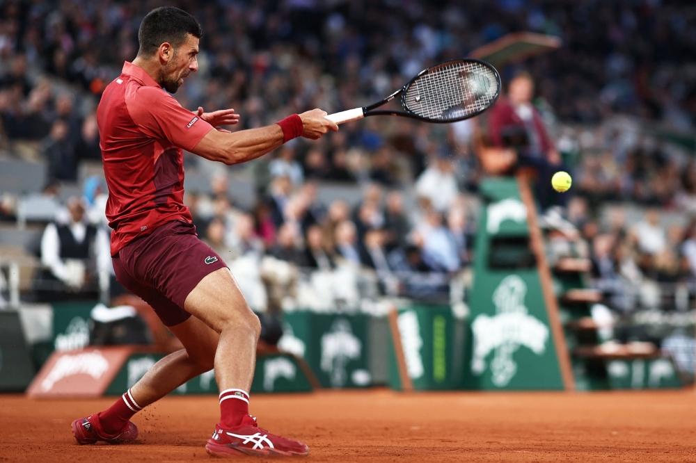 TOPSHOT - Serbia's Novak Djokovic plays a forehand return to France's Pierre-Hugues Herbert during their men's singles match on Court Philippe-Chatrier on day three of the French Open tennis tournament at the Roland Garros Complex in Paris on May 28, 2024.  (Photo by Anne-Christine POUJOULAT / AFP)

