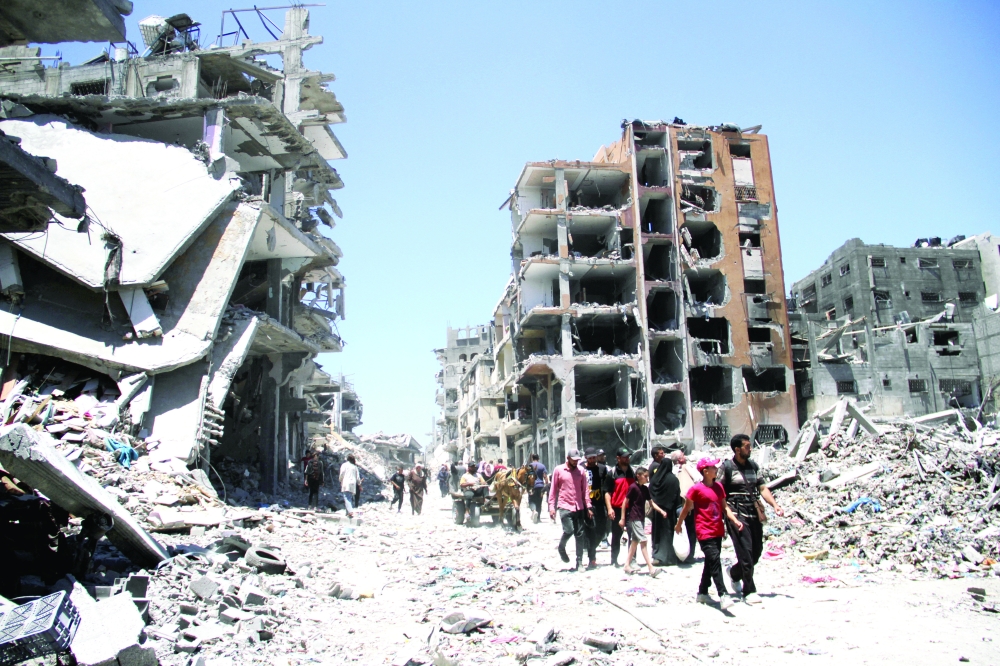 Palestinians inspect the damage after Israeli forces withdrew from Jabalia refugee camp on Friday. — Reuters