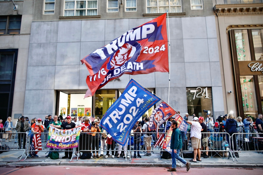 Supporters raise Trump-themed flags across the street from Trump Tower, in New York City, on May 31. — AFP 