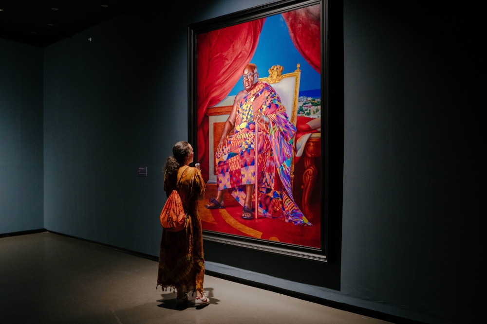 A visitor looks at a portrait of Nana Akufo-Addo, the president of Ghana, in the American painter Kehinde Wileys solo exhibition A Maze of Power at the Museum of Black Civilizations in Dakar, Senegal, May 17, 2024. (Carmen Abd Ali/The New York Times)