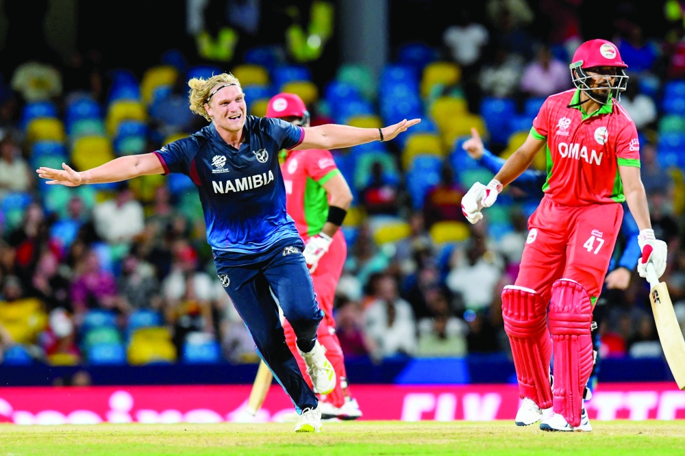 Namibia's Ruben Trumpelmann (L) celebrates the dismissal of Oman's captain Aqib Ilyas (R) during the ICC men's Twenty20 World Cup 2024 group B cricket match between Namibia and Oman at Kensington Oval, in Bridgetown, Barbados on June 2, 2024.   (Photo by Randy Brooks / AFP)

