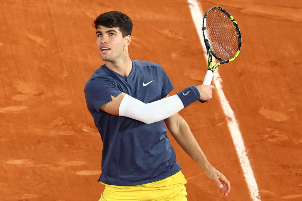 TOPSHOT - Spain's Carlos Alcaraz Garfia celebrates after winning against Greece's Stefanos Tsitsipas at the end of their men's singles quarter final match on Court Philippe-Chatrier on day ten of the French Open tennis tournament at the Roland Garros Complex in Paris on June 4, 2024.  (Photo by Emmanuel Dunand / AFP)

