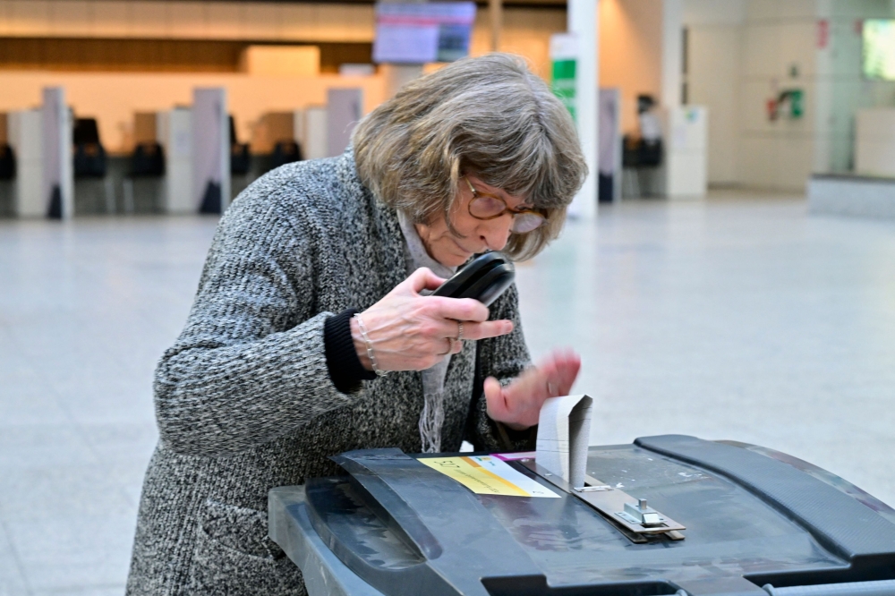 A woman casts her ballot for the European elections in a polling station, in The Hague on the first day of European Parliament election. - AFP


