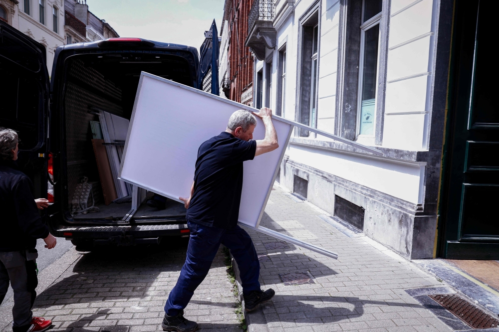 Municipal workers set up a polling station in Brussels ahead of the European Parliament election. - AFP


