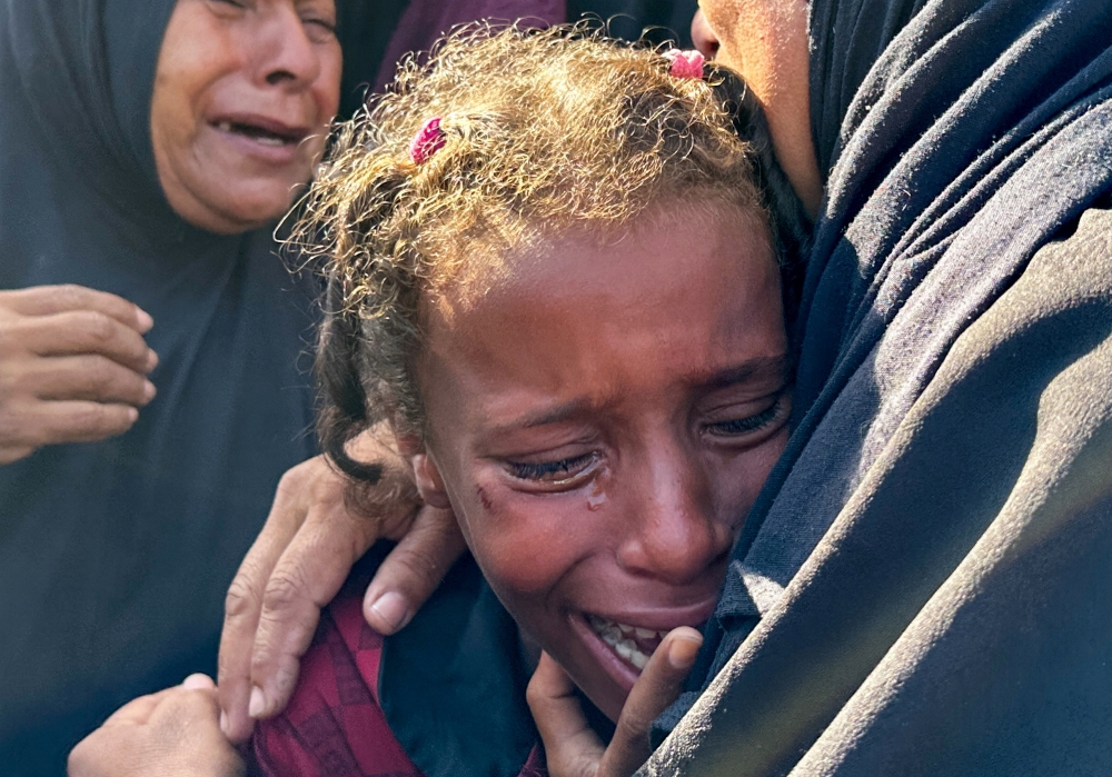 A mourner reacts during the funeral of Palestinians killed in Israeli strikes, amid the Israel-Hamas conflict, in Deir Al Balah, in central Gaza Strip.