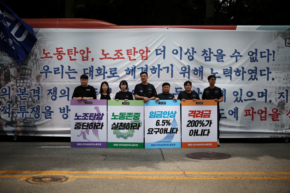 Members of National Samsung Electronics Union hold placards bearing their messages 