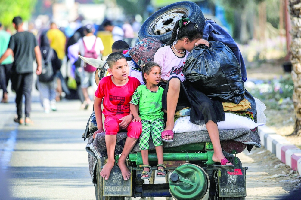 Children ride with belongings, moving with other displaced people fleeing from the eastern parts of Gaza. — AFP