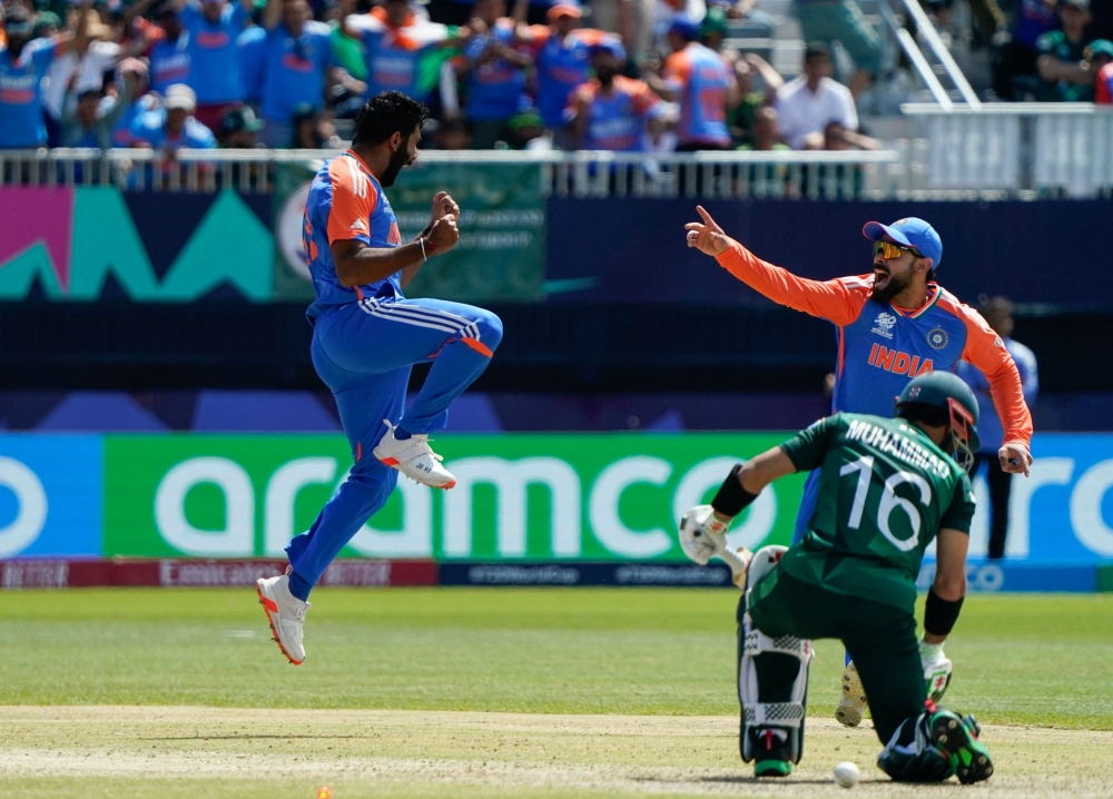 India's Jasprit Bumrah (L) celebrates after dismissing Pakistan's Mohammad Rizwan during the ICC men's Twenty20 World Cup 2024 