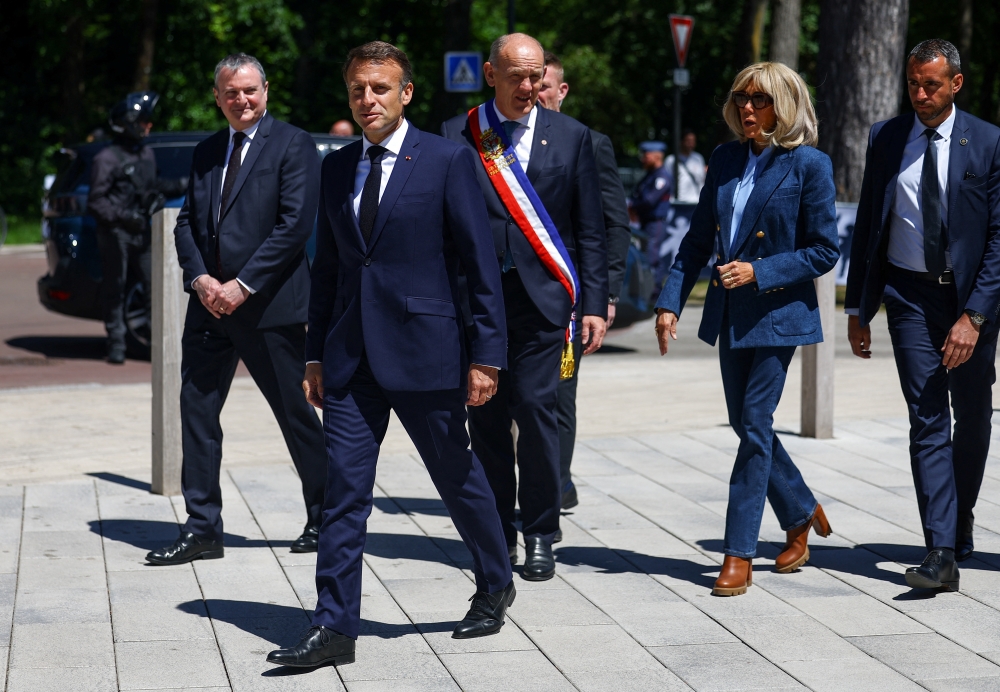 French President Emmanuel Macron walks with his wife Brigitte Macron and Daniel Fasquelle, mayor of Le Touquet-Paris-Plage, as they arrive to vote during the European Parliament election, outside a polling station in Le Touquet-Paris-Plage, France. — Reuters 