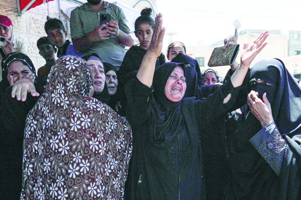 Family members mourn during the funeral of a man killed in Israeli bombardment, in Deir al-Balah. — AFP 