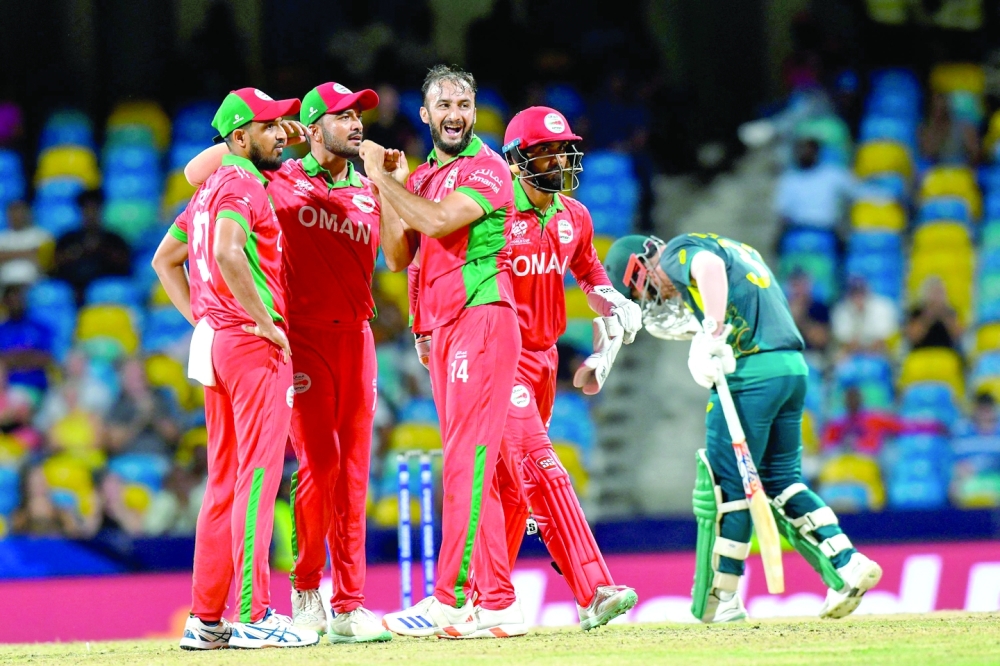 Oman's Mehran Khan (2R), captain Aqib Ilyas (L), Ayaan Khan and Pratik Athavale celebrate the dismissal of Australia's captain Mitchell Marsh during the ICC men's Twenty20 World Cup 2024 group B cricket match between Australia and Oman at Kensington Oval in Bridgetown, Barbados, on June 5, 2024.