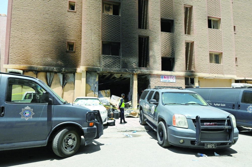 A Kuwaiti police officer is seen in front of a burnt building following a deadly fire, in Mangaf, southern Kuwait. — Reuters 
