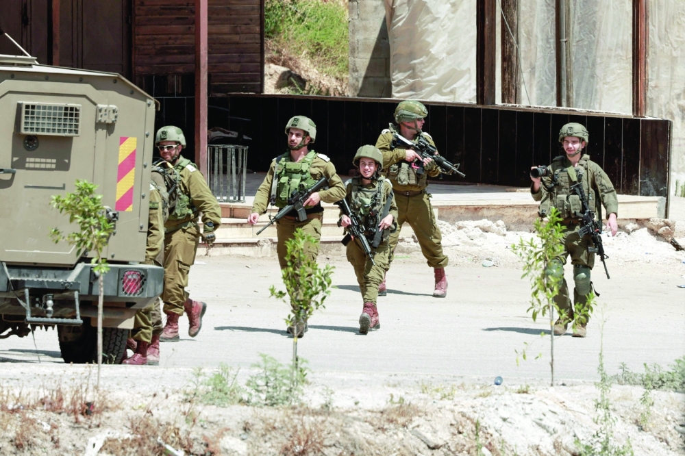  Israeli forces walk on a street during a raid in the al-Faraa camp for Palestinian refugees near Tubas city in the West Bank. — AFP 