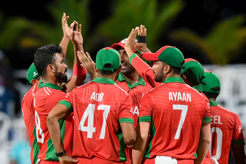 Oman's Bilal Khan celebrates the dismissal of Australia's Travis Head during the ICC men's Twenty20 World Cup 2024 group B cricket match between Australia and Oman at Kensington Oval in Bridgetown, Barbados, on June 5, 2024.  (Photo by Randy Brooks / AFP)

