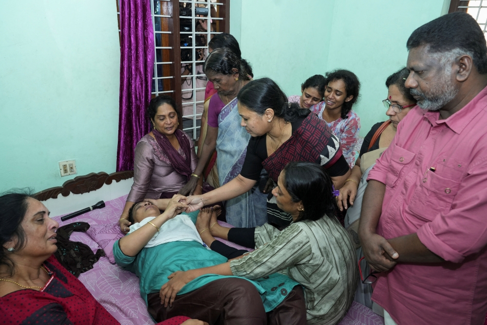 Kerala Minister for Health and Woman and Child Development Veena George consoles the mother of Akash Sasidharan Nair, one of the victims of a fire that broke out in a building housing foreign workers in Kuwait, at Pathanamthitta district in the southern Indian state of Kerala. - Reuters

