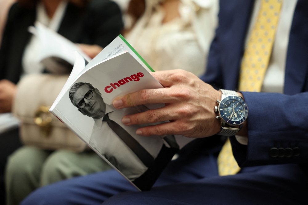 A person holds Britain's Labour Party election manifesto on the day of its launch in Manchester. - Reuters
