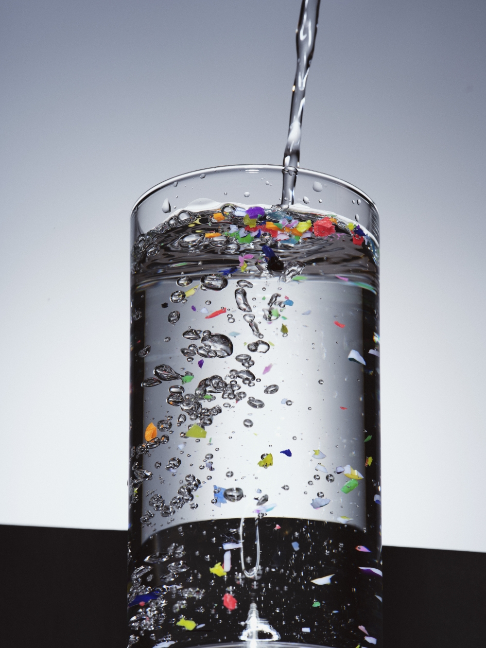 A photo illustration of plastic pieces in water. Furniture, clothing and food packaging can all shed tiny particles that can end up in our bodies. (Ryan Jenq/The New York Times)