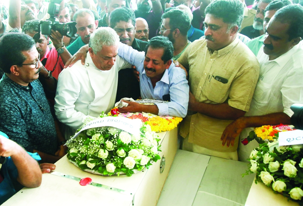 Father of Cibin Thevarottu Abraham, one of the victims of a fire that broke out in a building housing foreign workers in Kuwait, cries next to the coffin containing the body of his son at Cochin International Airport, Kerala