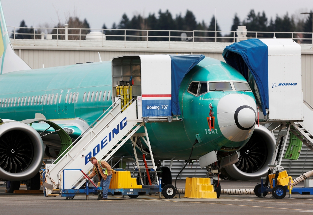 An employee works near a Boeing 737 Max aircraft at Boeing's 737 Max production facility in Renton, Washington. — Reuters