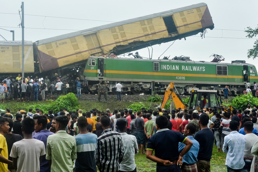 People gather near the site of a collision between an passenger and a goods train in Nirmaljote, near Rangapani station in India's West Bengal state on Monday. — AFP