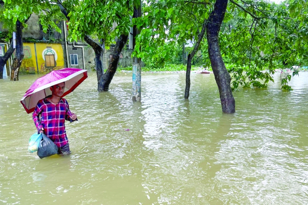 A man wades through flood waters in Sylhet. - AFP


