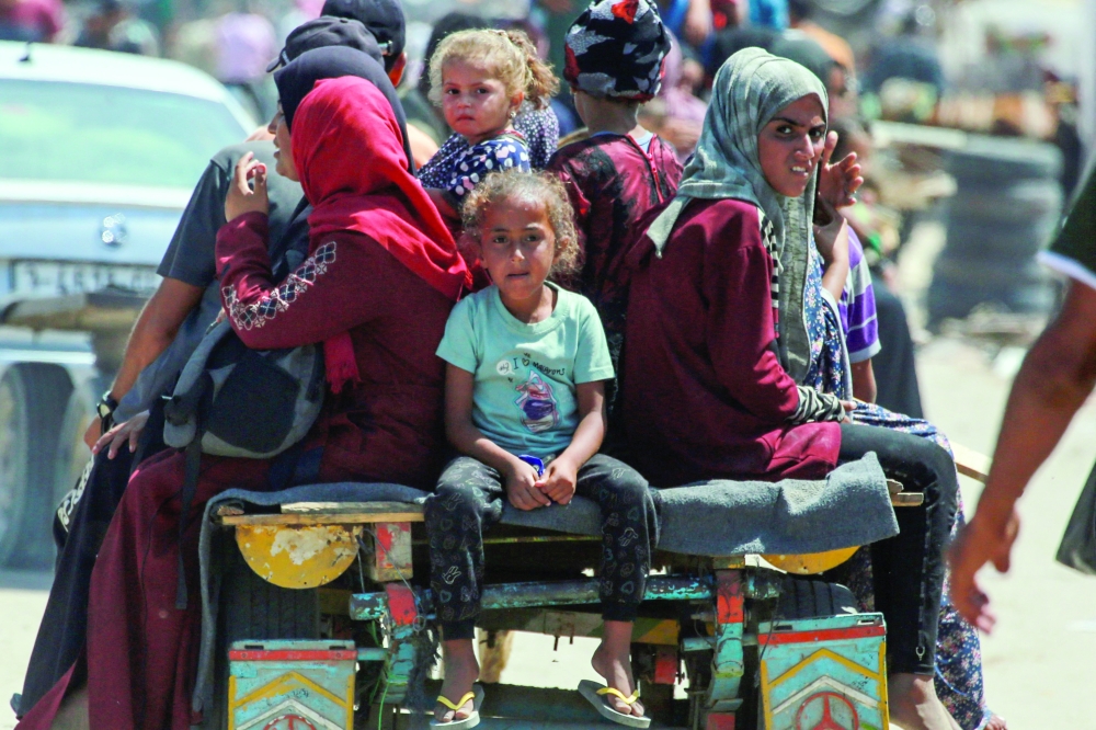Palestinians ride in an animal-pulled cart in an area housing displaced people in Rafah, in the southern Gaza Strip, amid the ongoing conflict in the Palestinian territory between Israel and Hamas. - AFP